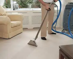 Carpet cleaning professional removing dirt and stains with a hot-water extraction tool in a home, Ogden, UT.
