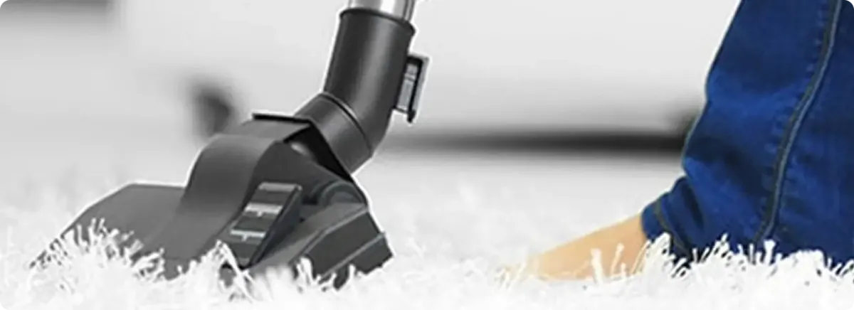 Close-up of a professional vacuuming a white carpet in Clearfield.